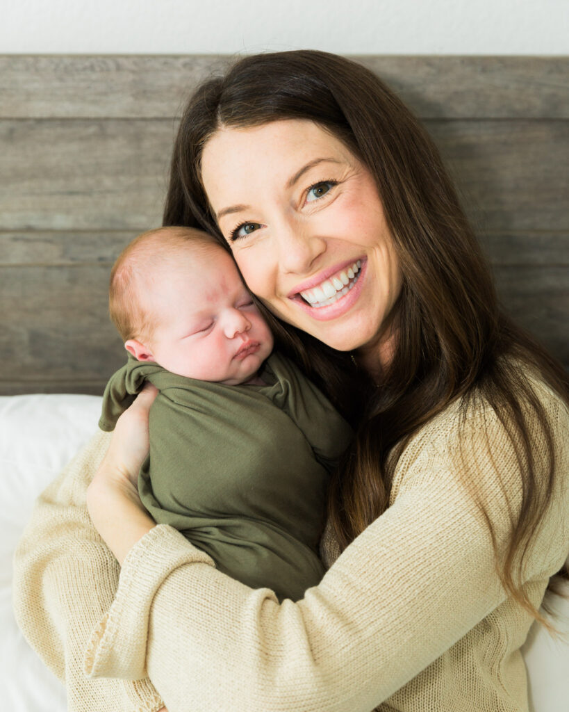 Mother cuddling her newborn son during an intimate in-home newborn photography session.