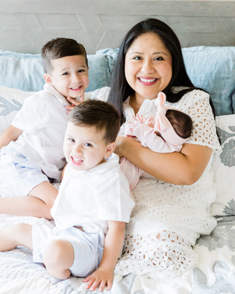 Family cuddling together on bed during newborn session